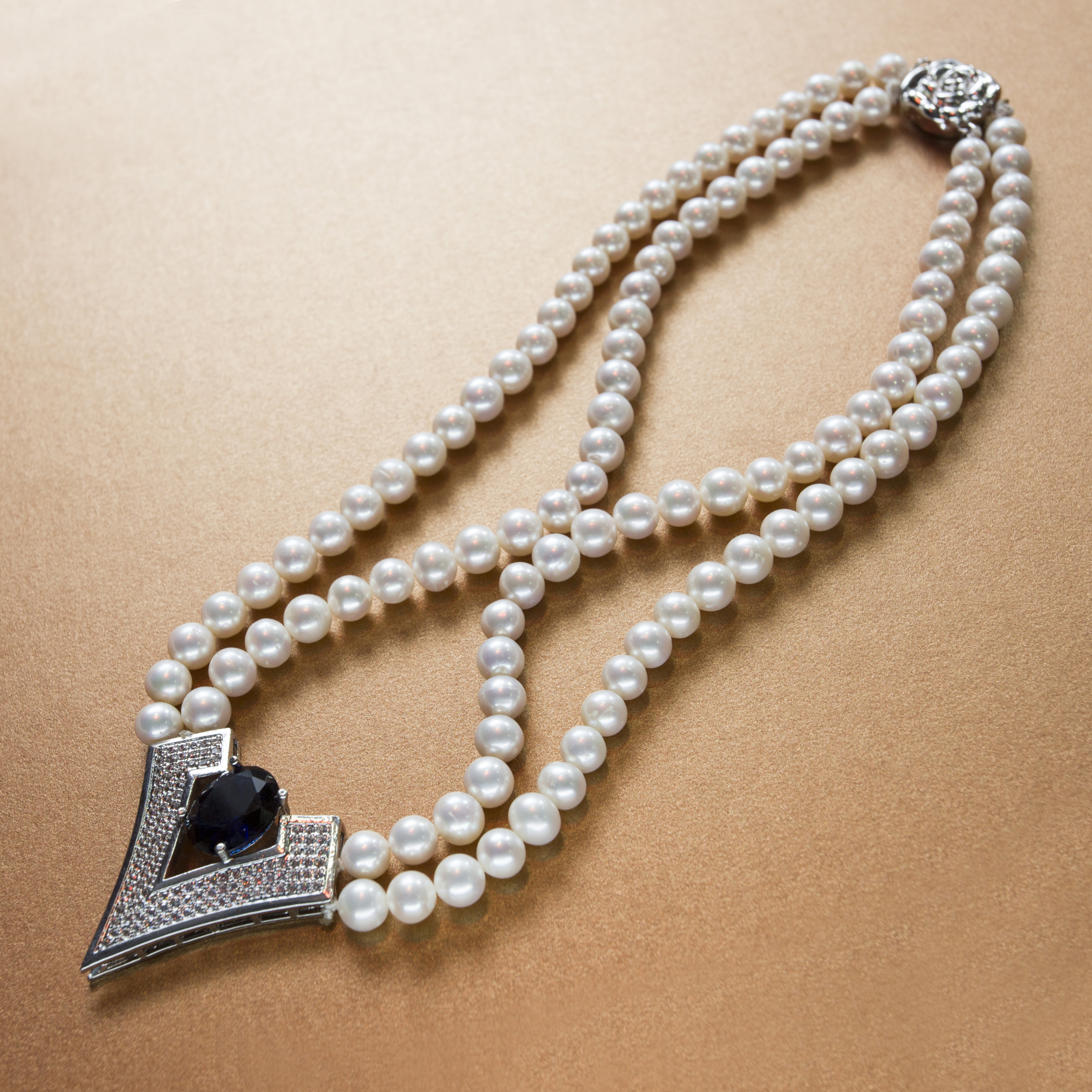 Classic diamond  and blue sapphire stone studded Vendetta white pearl double stranded necklace- with silver floral clasp