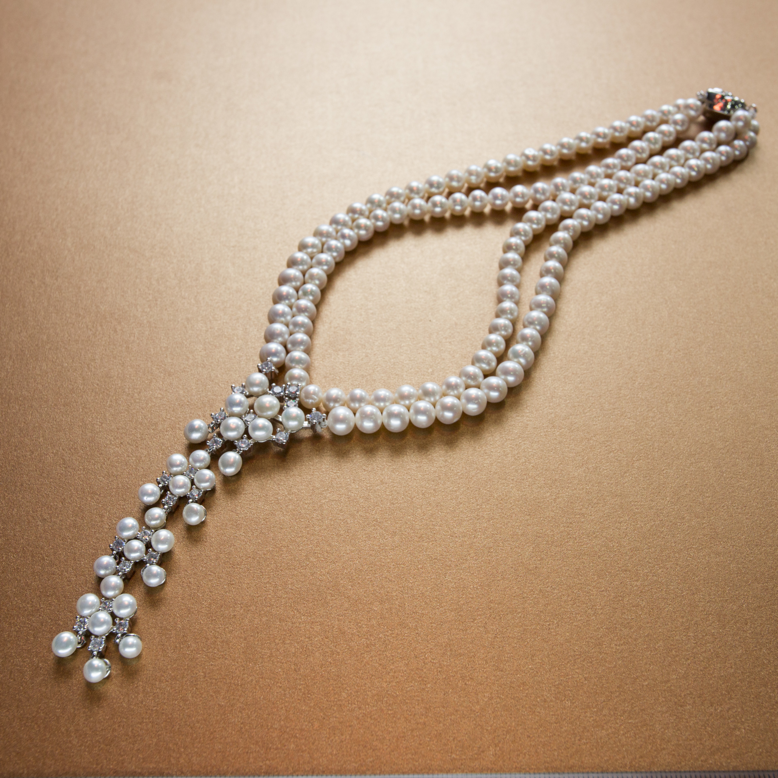 Classic pearl and diamond studded double stranded white pearl necklace- with silver floral clasp